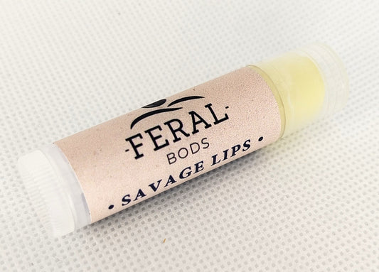 Tallow, lanolin, and beeswax-based Lip balm with 'Feral Bods' branding on a textured white background. Feral Beauty brand