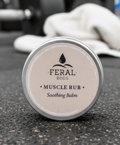 Feral Bods Muscle Rub tallow Soothing Balm container on a dark surface