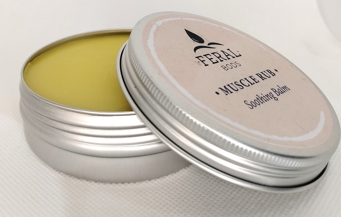 Feral Bods Soothing muscle rub balm in a metal tin with a white lid. Tallow skincare